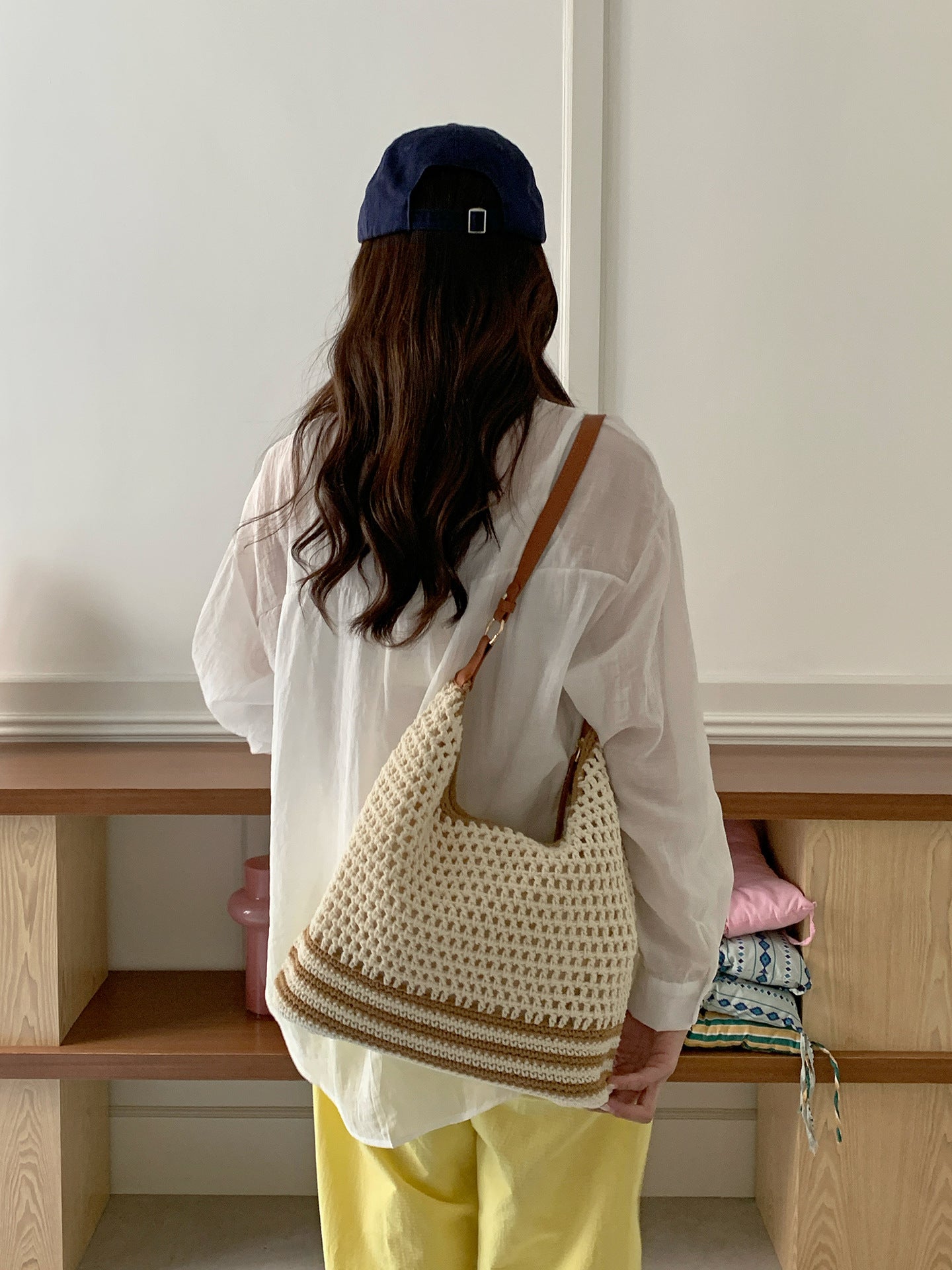 Soft cream crochet style shoulder bag with a slim brown adjustable strap