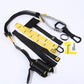 Black and yellow TRX suspension straps foam handles and carabiner arranged on white surface
