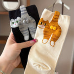 Pair of cartoon cat mid crew socks in black and cream held up in hand
