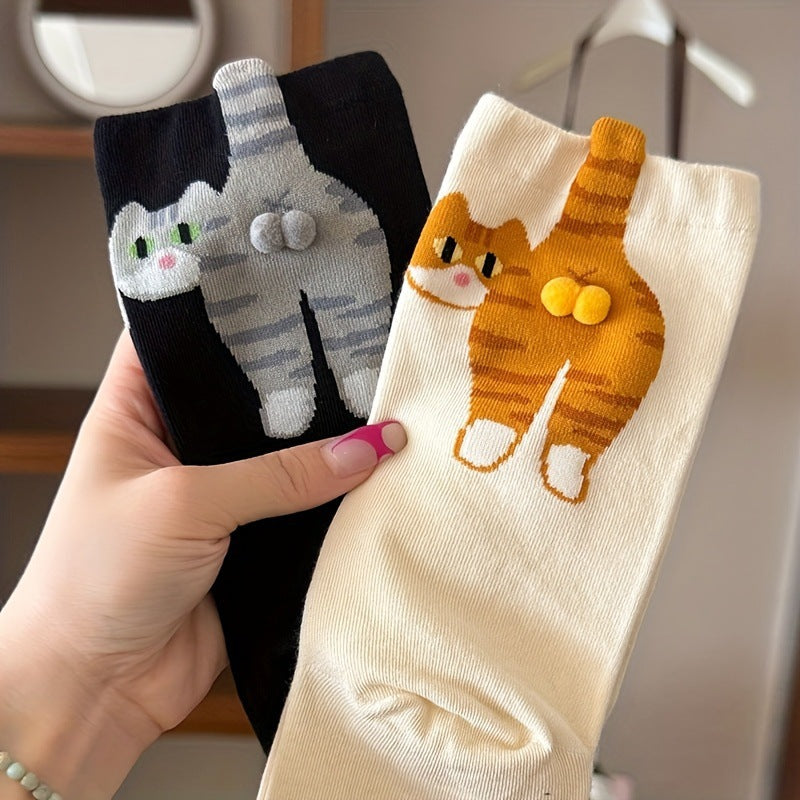 Pair of cartoon cat mid crew socks in black and cream held up in hand