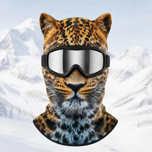 Leopard print fleece balaclava with ears and silver goggles on a snowy mountain