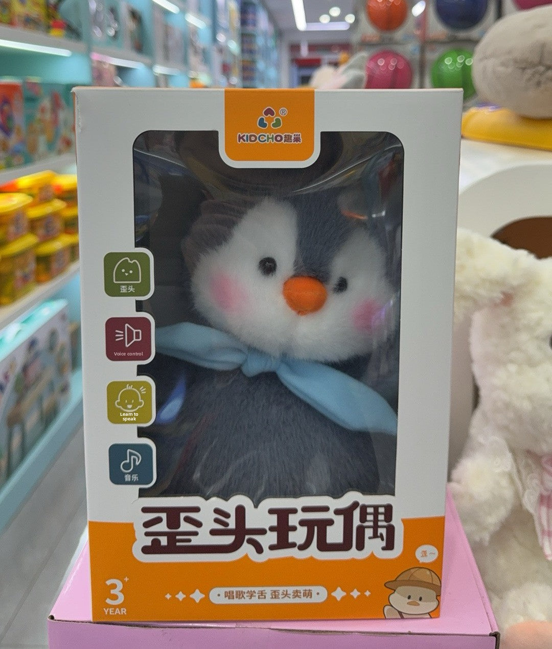 Penguin musical plush inside its transparent window gift box on a store shelf