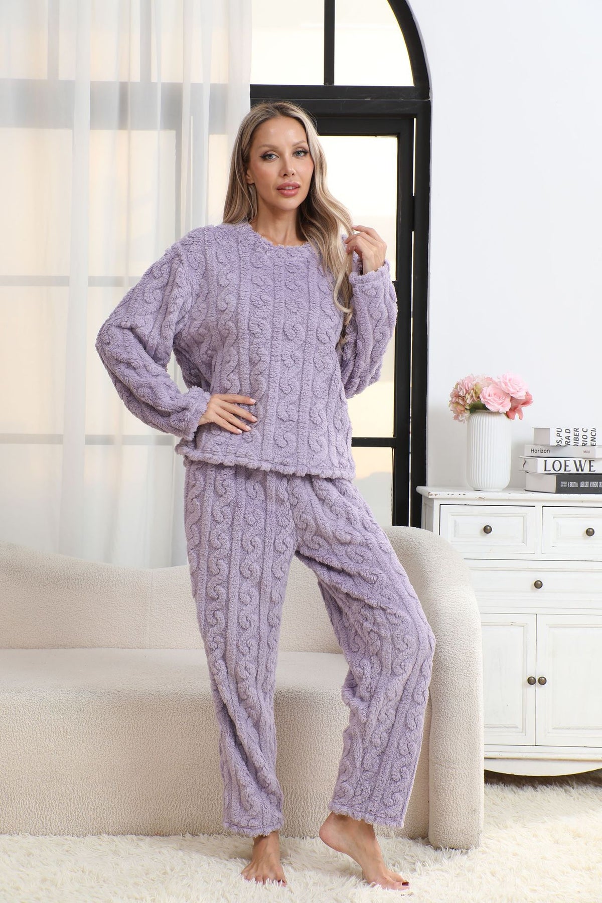 Woman in a purple lavender coral fleece pajama set with a cable-like jacquard texture, round neck and long sleeves