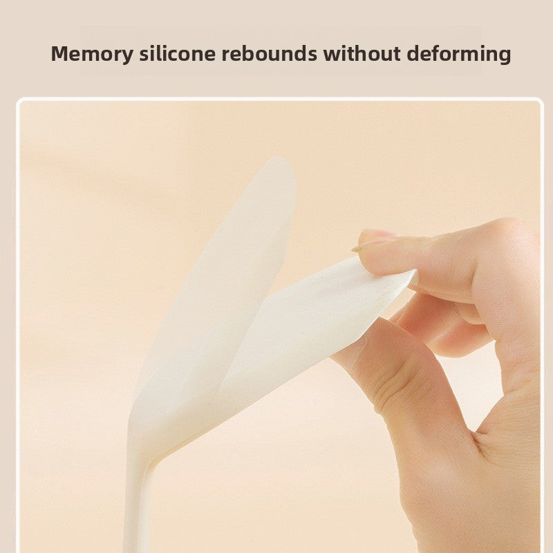 White silicone turner head bent by hand to show the flexible food grade silicone
