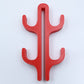 Red resin four hook with four arms, seen from the front on a light background