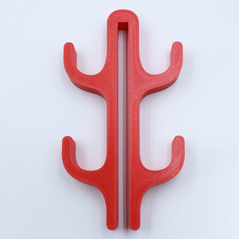 Red resin four hook with four arms, seen from the front on a light background