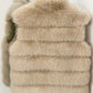 Dark Beige tiered vegan fur sleeveless vest on a hanger showing six horizontal fur tiers