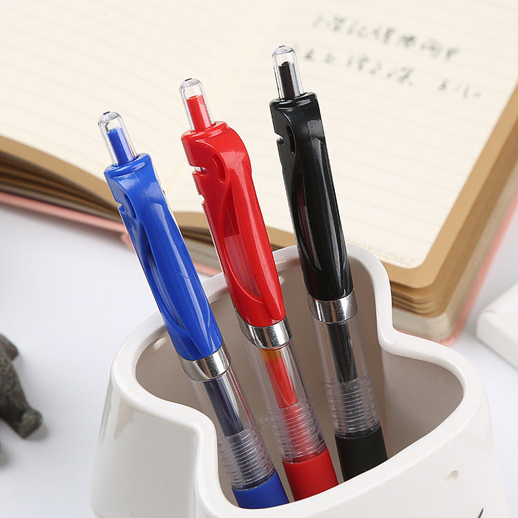 Blue, red and black retractable gel pens standing in a white heart shaped pen cup