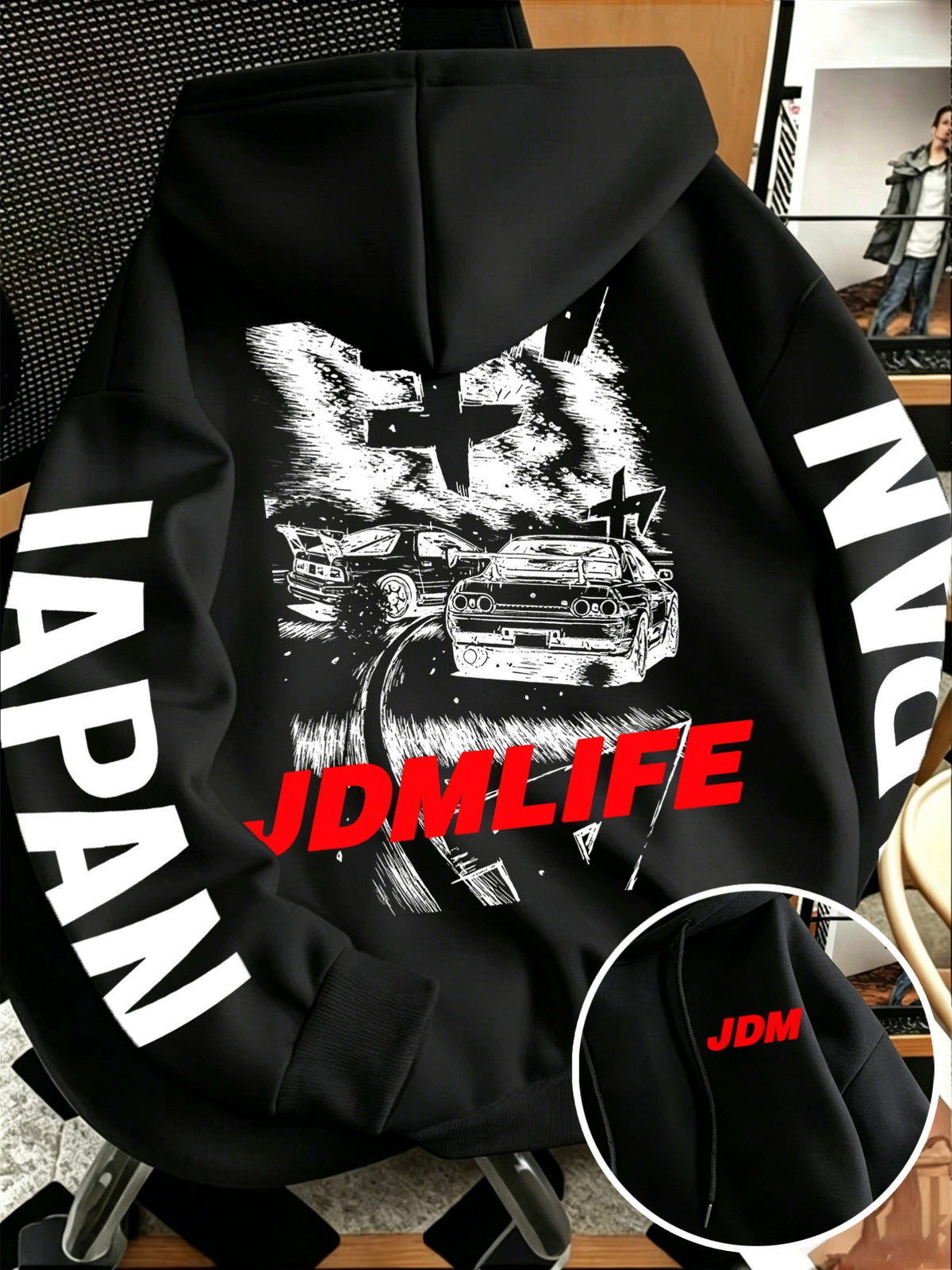 Front pocket detail of the JDM hoodie with a small red JDM tag beside the pouch pocket