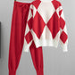 Red argyle knit sweater with white panels and matching red drawstring jogger pants on hangers against a white background