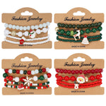 Four cardboard cards each holding a set of four Christmas bead stretch bracelets in white, green, mixed and red