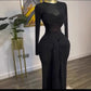 Black long sleeve maxi dress on a mannequin, close view of the twisted bust and front drape