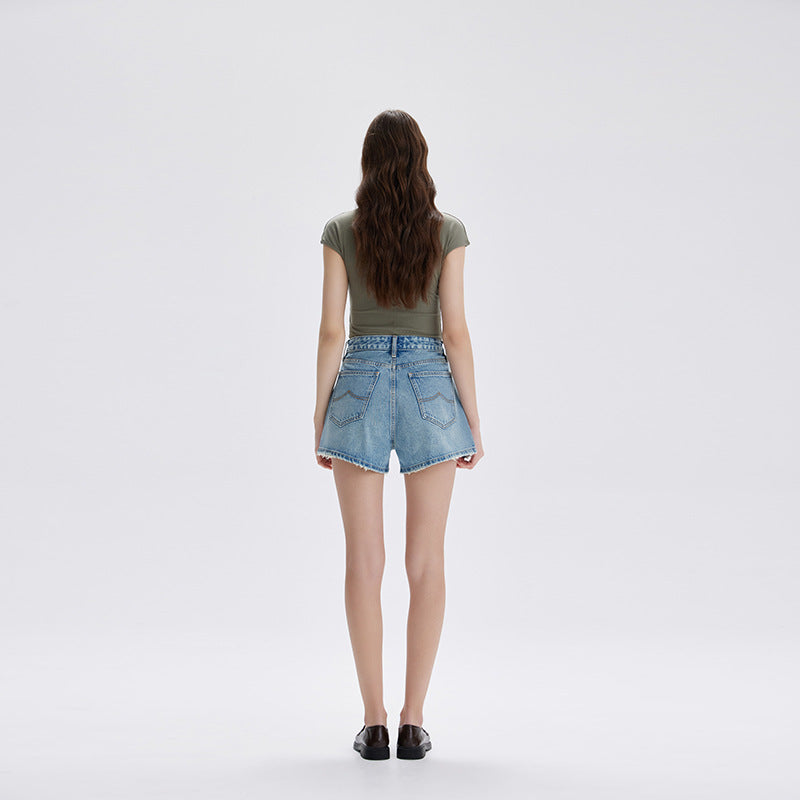 Back view of light blue denim shorts showing patch pockets and frayed hem