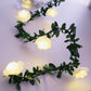 Warm White flower LED fairy string light on a green leaf vine with a warm glow, decorative photo