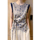 Gray diamond print sleeveless blouse with navy trim and side knot on model