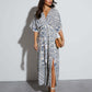 Full length ivory and cobalt paisley maxi dress, front view with a straw clutch, White blue variant