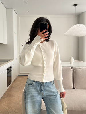 Model wears the rib knit cardigan buttoned down the front with the fitted waist visible