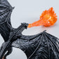 Close-up of the black textured dragon with spread wings breathing a translucent orange flame on a pale background
