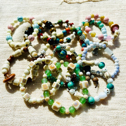 Handmade ceramic beads strand laid out, earth-tone glazed clay beads on cord
