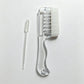 Transparent white scalp liquid comb with white soft rubber cover and a dropper pipette on a light surface, OPP bag option