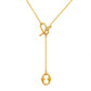 Gold tone lariat necklace held in hand to show the toggle and pendant scale