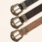 Black western floral embossed PU belt with an ornate antique brass pin buckle laid flat