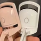 Close photograph of the pink and white eyelash curlers showing the heated comb in the head