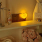 Warm amber heart night light glowing beside a wall socket in a cozy room