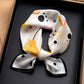 White and grey cat print printed square scarf with a satin sheen and hemmed edges, shown displayed