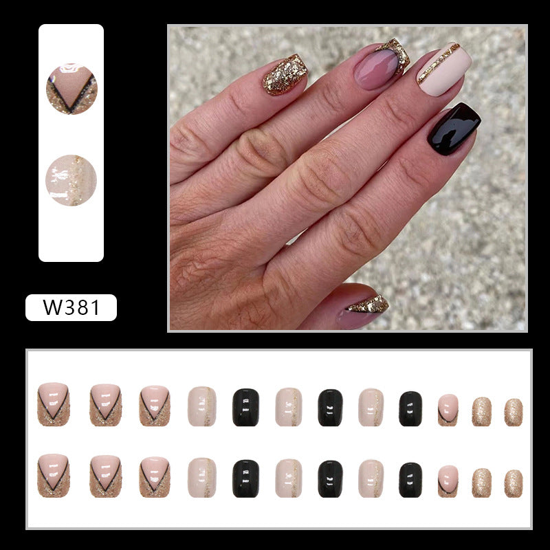 Full cover press-on almond nails in a black and gold glitter, glossy finish shown on a hand