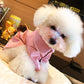 White bichon wearing the pink pet pajama shirt with white piping along the collar and placket