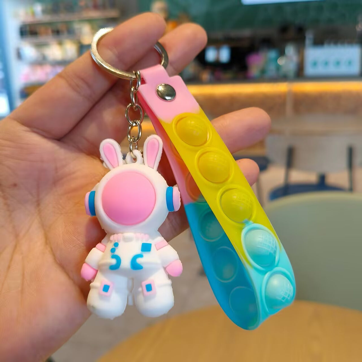 Pastel silicone wrist strap lined with push pop bubbles and a metal press stud on the keychain