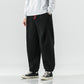 Black plush harem pants with red drawcord, front view with white sweatshirt and high top sneakers