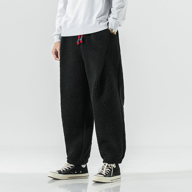 Black plush harem pants with red drawcord, front view with white sweatshirt and high top sneakers