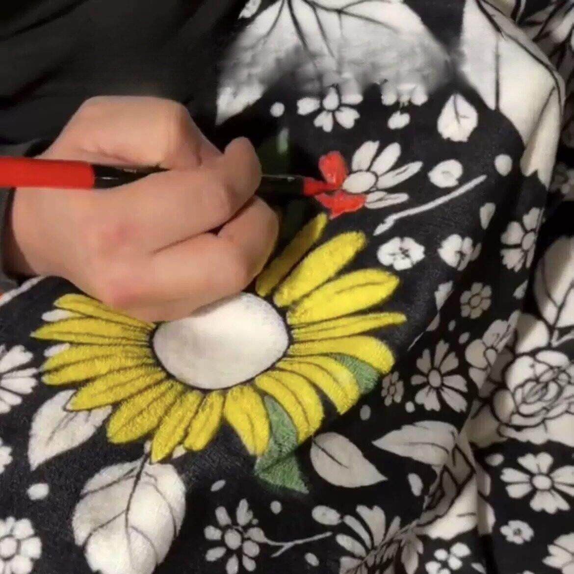 Close view of a sunflower being colored yellow and green on the kids coloring blanket