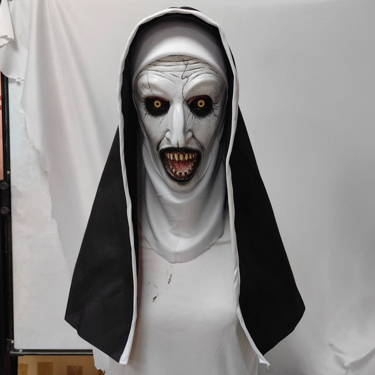 Detail of a horror nun latex mask showing carved wrinkles and pale skin
