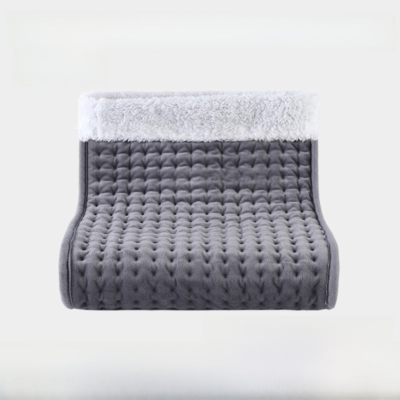 Gray quilted electric foot warmer with a white plush cuff on a pale background, UK plug option