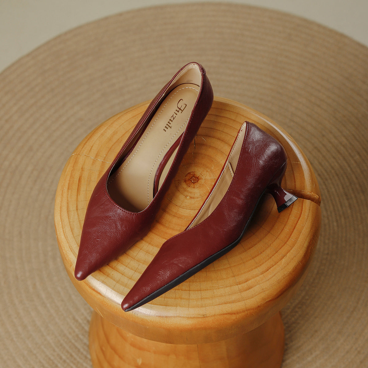 Pair of burgundy pointed toe pumps with a low flared heel on a wooden stool, Burgundy option, size 38