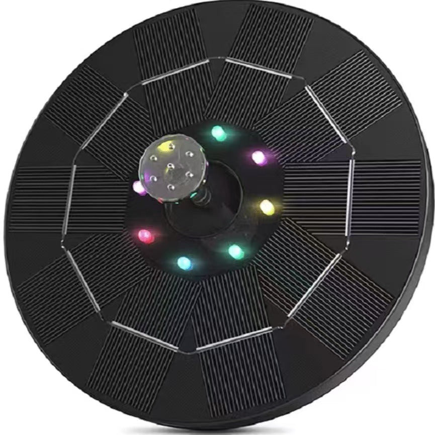 Top view of a round black solar fountain panel with colored LED beads around the central spray head