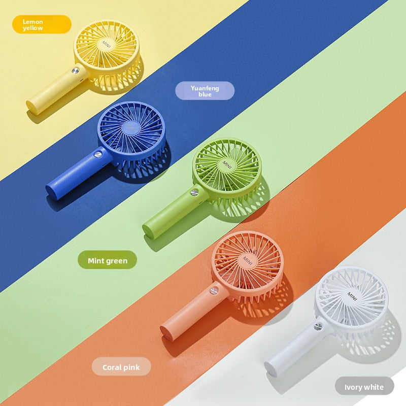 Mini USB fan propping a phone upright in its fold out base groove