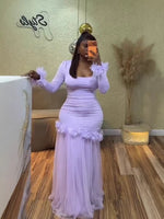 Woman in a light purple long sleeve maxi dress with rosette cuffs and a mesh skirt taking a mirror selfie