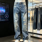 Blue washed jeans with knee rips and frayed hems on a mannequin beside a second pair on a hanger