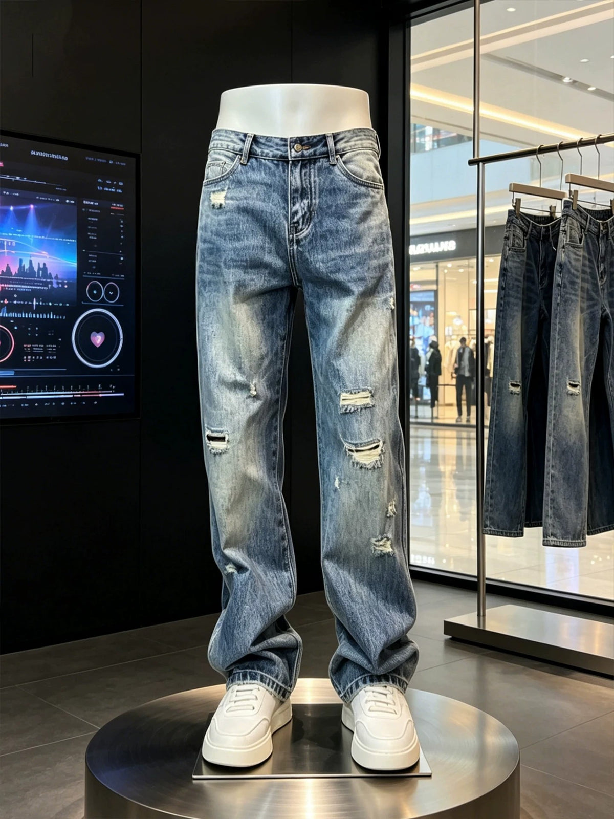 Blue washed jeans with knee rips and frayed hems on a mannequin beside a second pair on a hanger