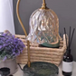 Glass lily shade lamp glowing over a jar candle