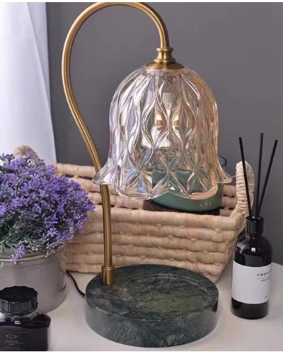 Glass lily shade lamp glowing over a jar candle