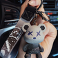 Silicone bear charm on a printed nylon wrist strap with a metal ring and lobster clasp