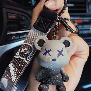 Silicone bear charm on a printed nylon wrist strap with a metal ring and lobster clasp