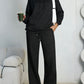 Black fleece hooded sweatshirt and wide-leg sweatpants set worn by a model