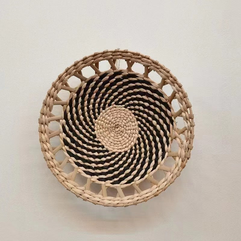 Woven straw wall disc with a wood-toned open rim hung on a plain wall