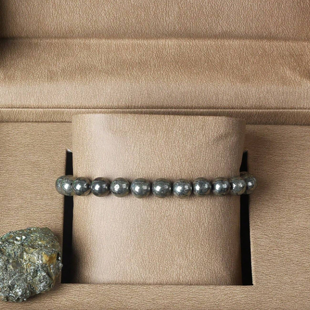 Close up of polished pyrite beads with brassy gold sheen and grey flecks on cord